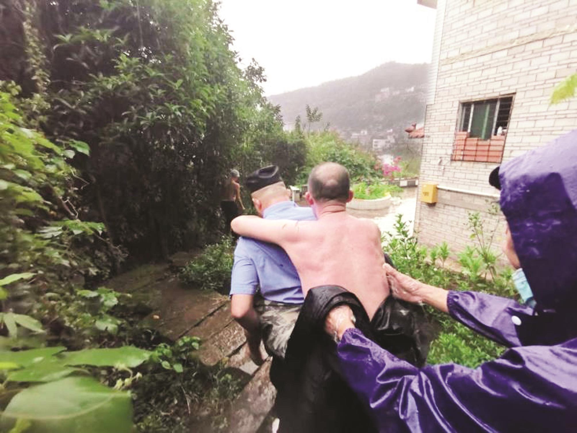 老人迷路摔倒在荒山坡上 民警冒雨赤脚背着他转移
