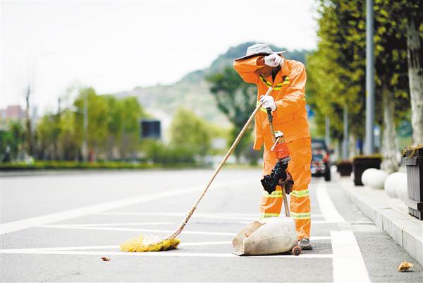 挥汗清扫 8月7日,渝北区悦来街头,环卫工人在烈日下清洁路面.