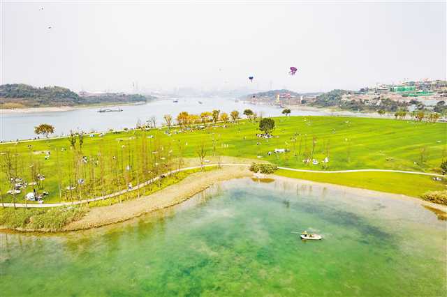 重庆广阳岛,工人在湖中作业,游客在岛上露营游玩享受美景.