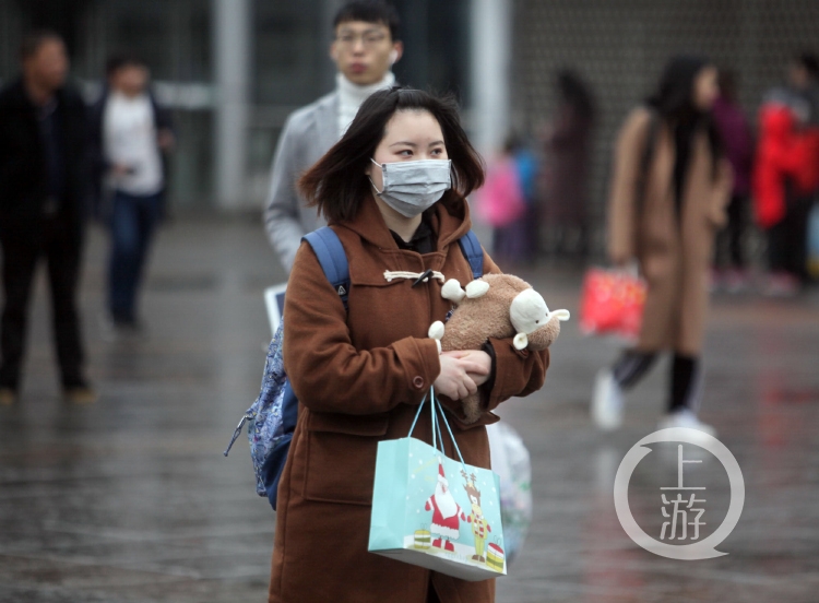 寒冷的冬日,街头的市民戴口罩遮挡寒风.