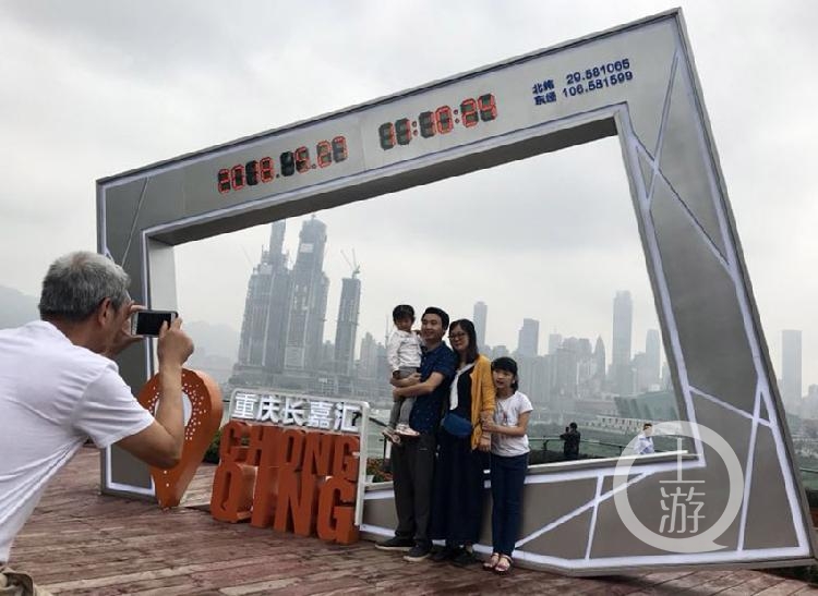 南滨路超级大相框前,市民以城市为背景,开心留影.