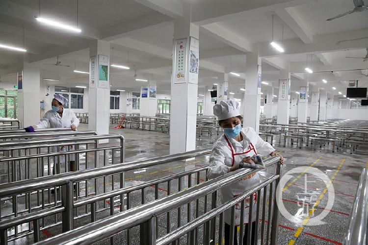 食堂员工擦拭排队领餐栏杆.