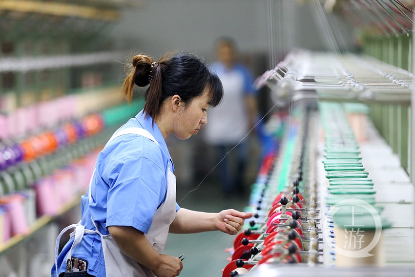 5月13日,重庆市黔江区花神纺织公司,女工在生产车间进行并丝劳作.
