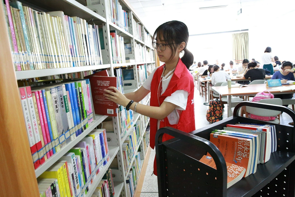 7月24日,沙坪坝区图书馆报刊阅览室,四川美术学院大一学生佘笙蜻正在