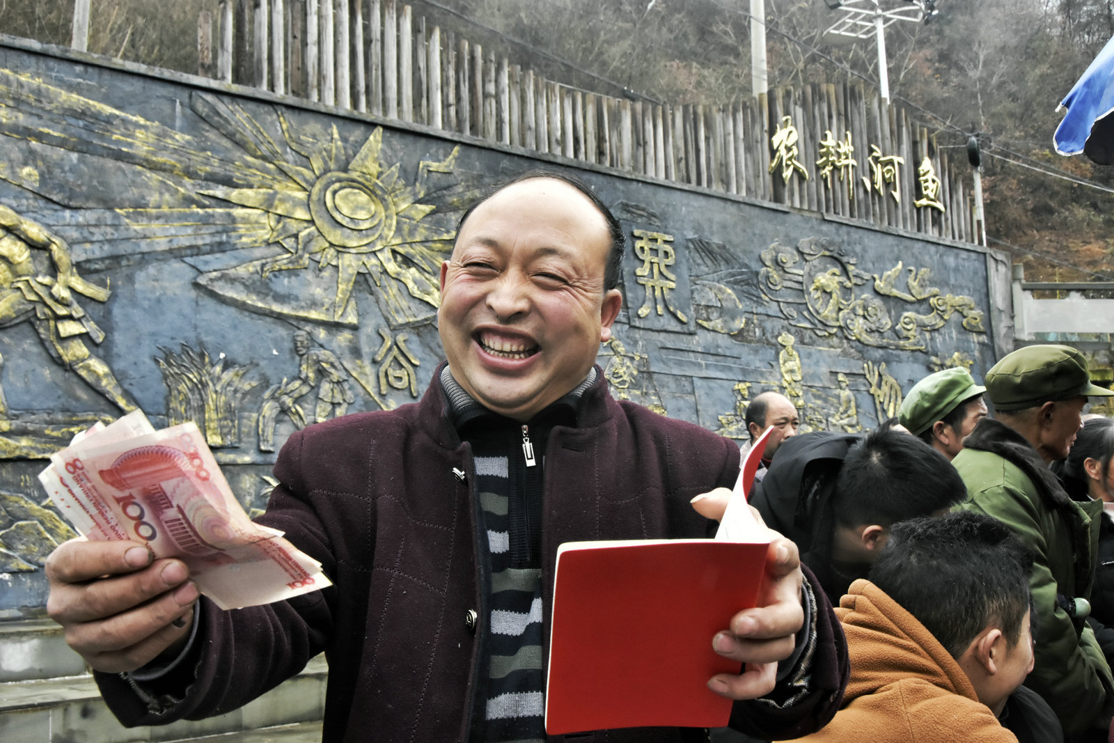 重庆市城口县河鱼乡平溪村分红大会现场.村民廖远国拿到分红喜笑颜开.