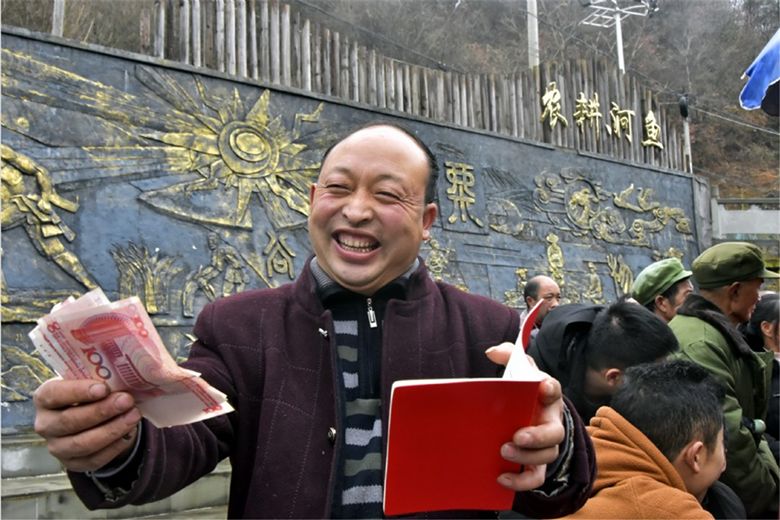 河鱼乡平溪村村民廖远国领到分红笑逐颜开.