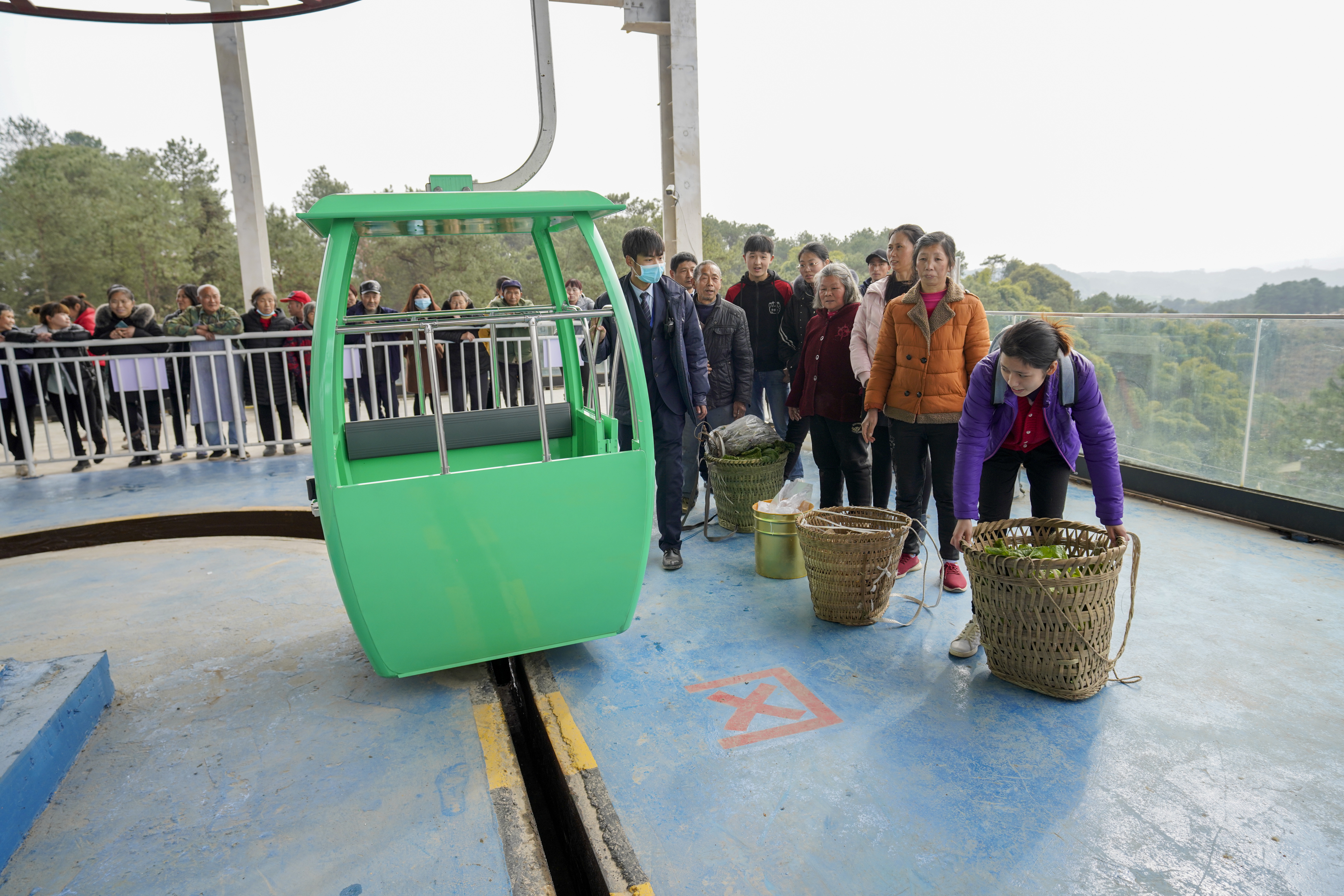 2月9日,涪陵区蔺市镇泡桐村农民带着自家的农特产品排队乘坐索道,前往