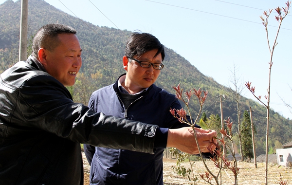 在福坪村的村级道路上,竹贤乡党委书记曾云峰与村支书黄文刚一起