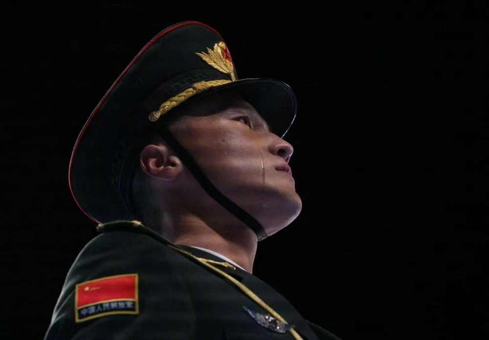 中,摄影记者施耐德拍到鸟巢体育场内,一位中国军人眼泪滑落脸庞的照片
