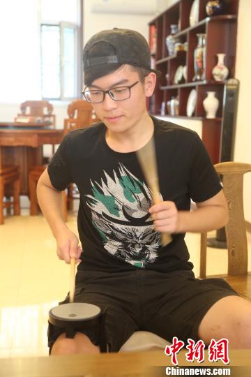 每当闲暇时，赵子腾会将碗口大的小鼓绑在腿上进行演奏。　刘哲 摄