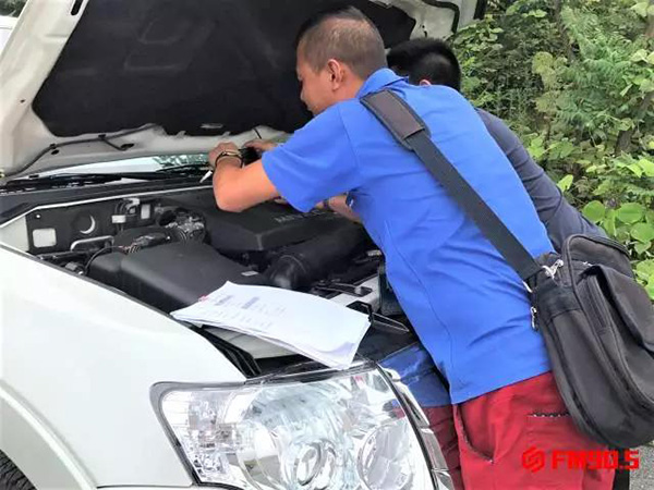 郴州市公安局交警支队万华汽车城车辆管理分所工作人员（蓝衣男子）在检查李先生的帕杰罗。