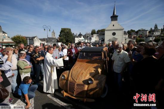 当地时间2017年9月23日，法国洛什，法国木工Michel Robillard用果木手工打造了一辆雪铁龙2CV汽车。图为牧师为这辆奇特的汽车祈福。