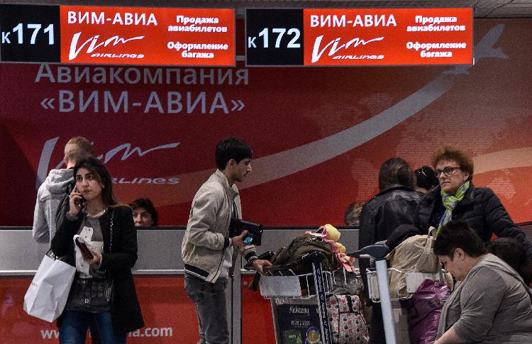 9月26日，在俄罗斯莫斯科多莫杰多沃机场，旅客聚集在维姆航空公司柜台前。（新华社/法新）