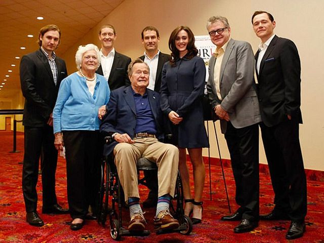 2014年3月，美国前总统老布什夫妇（前左、前左2）与电视剧《逆转骑兵》剧组成员合影。站在老布什身旁的女演员为希瑟·林德。（图片来源：英国《每日邮报》）
