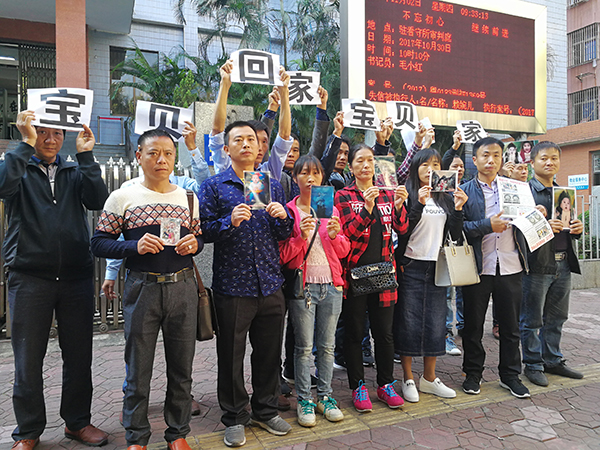 2017年11月2日，庭审之前，9名被拐孩子的家人合影，渴望“宝贝回家”。 澎湃闻闻记者 朱远祥 图