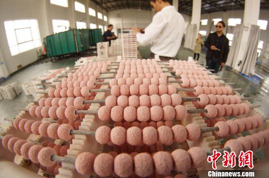 工人正在批量生产陶瓷珠宝。　王昊阳 摄