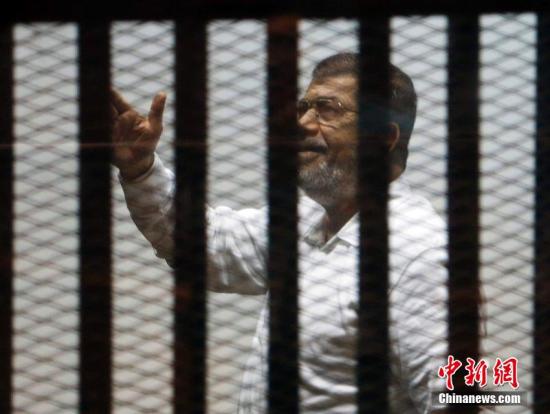 资料图：2014年11月18日，埃及开罗，埃及前总统穆尔西和其他穆兄会成员一起出庭受审。图片来源：CFP视觉中国