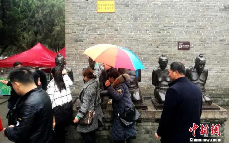 游客冒雨拍打秦桧等5人铁铸像。刘鹏 摄.jpg