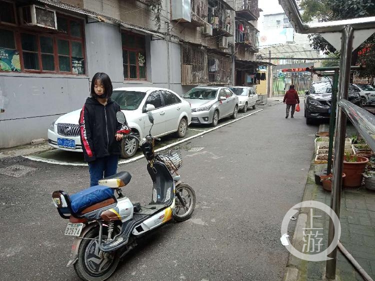 杨杨站在爸爸亲手做的加厚坐垫的电动车旁。牛泰摄影.jpg