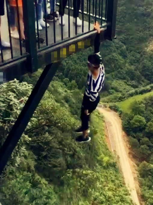 胆战心惊！一小伙重庆景区廊桥外悬空倒挂做仰卧起坐.jpg