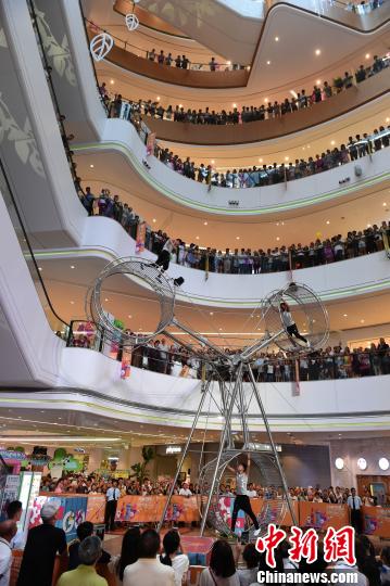 图为重庆一商场上演的飞轮秀吸引众多民众围观。　周毅 摄