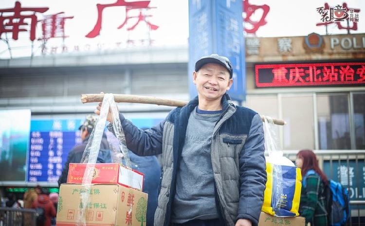 “这是给家人带的苹果。”重庆北站南广场，60岁的田云树肩头挑着两箱沉沉的苹果，笑容灿烂。田云树老家在广安，现在在重庆主城一家门业厂打工。