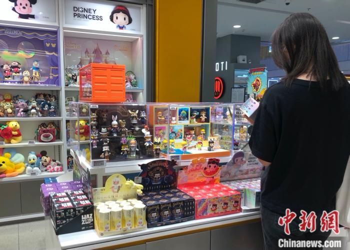 资料图：消费者在泡泡玛特门店挑选Molly盲盒。 <a target='_blank' href='/' >中新网</a> 左宇坤 摄