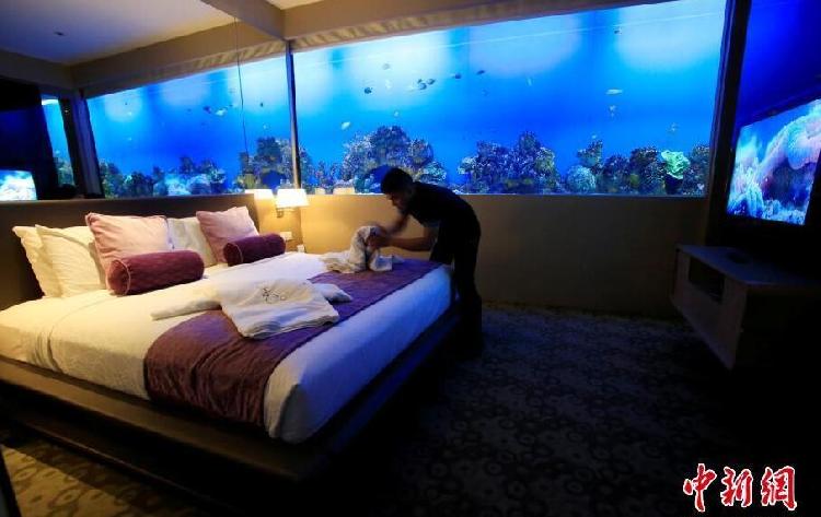菲律宾首都马尼拉，一名员工在H2O酒店内收拾房间，整套房间被营造出睡在海底的效果，不仅有鱼缸墙，连电视和灯光都与环境配套。.jpg