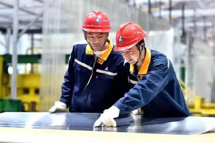 在西南铝压延厂区，两名员工在检测铝板表面质量，该材料将用于军工用品  摄影 周燕.png