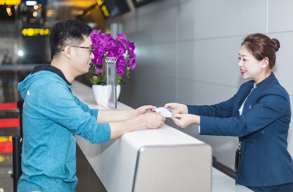 重庆机场创新推出的“三跨”中转服务，中转服务工作人员正在为旅客服务.jpg