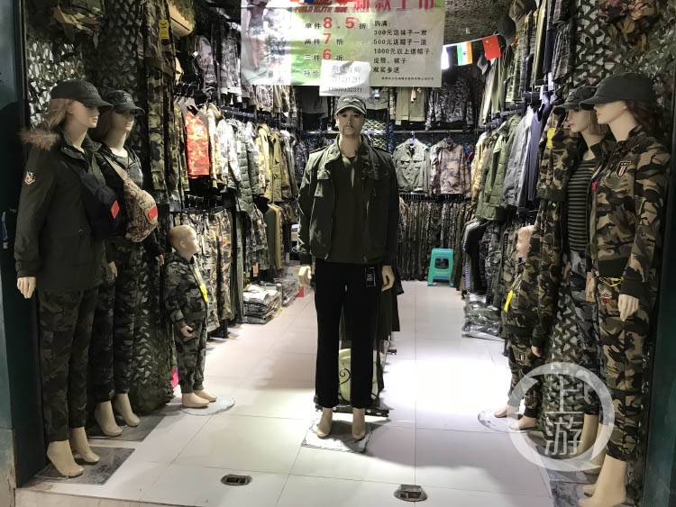 渝中区一服装店,门口穿着迷彩衣服的模型人如守门将士