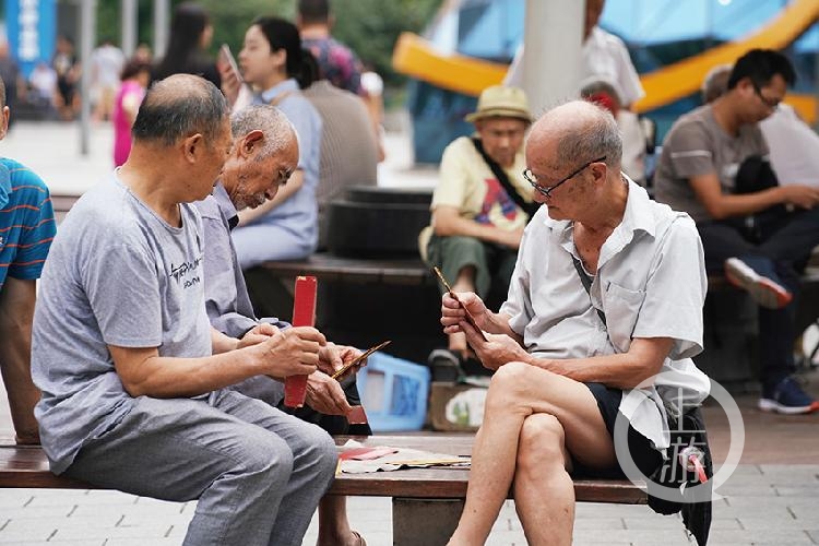 楊家坪,老人們坐在凳子上打牌娛樂.