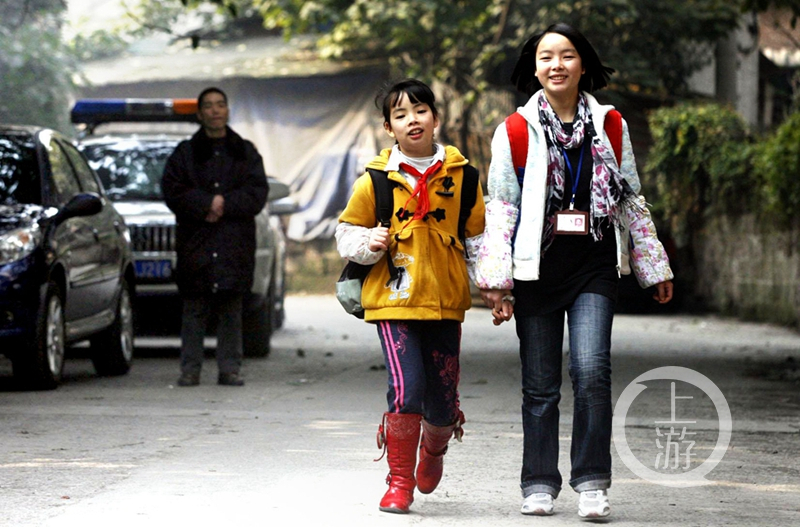 13 2009年12月，在恒生手外科医院当保安的父亲冯邦武的目送下，冯氏姐妹高高兴兴的走在上学的路上，姐姐冯雪梅还当上了班长。.jpg